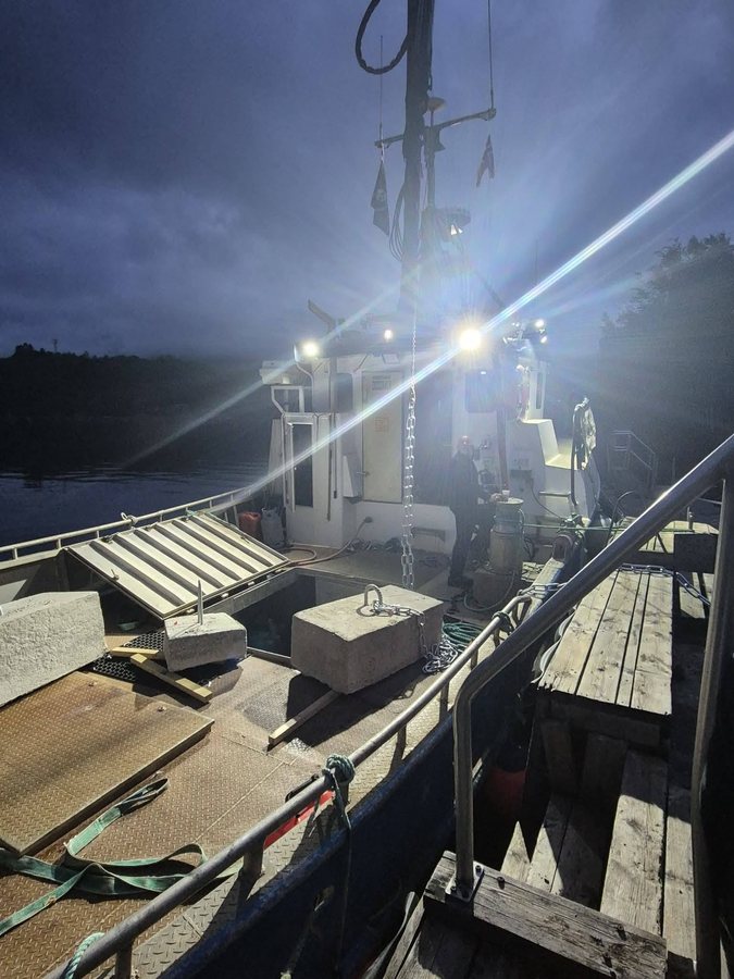 Ilesteiner i betong på dekk, klare til utsetting, med kjetting i kroken og dekkslysene på.